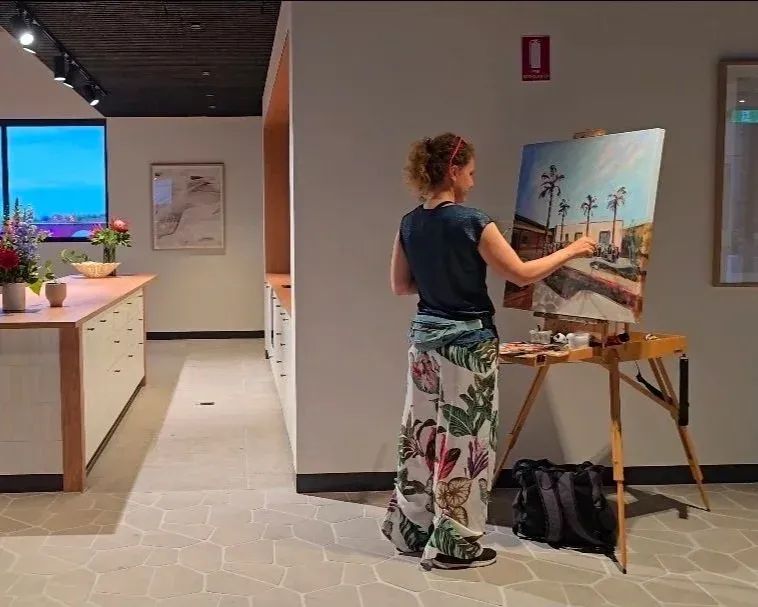 Live event painter, Olga, painting a landscape on canvas at an Event in Melbourne